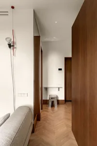 A modern living room with wooden flooring and minimalist design elements.