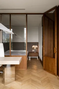 Modern minimalist bedroom with wooden furniture and a white bed.