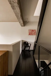 A modern loft interior featuring exposed concrete and wooden floors.