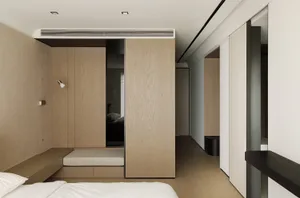 A minimalist bedroom with wooden walls, flooring, and furniture.