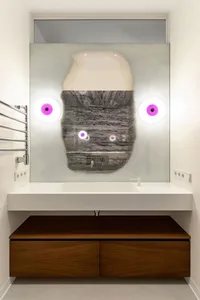Modern minimalist bathroom featuring a glass vanity with integrated sink, wooden storage units, and a unique, abstract design