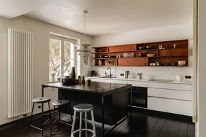 Modern minimalist kitchen with wood and concrete materials and open shelving.
