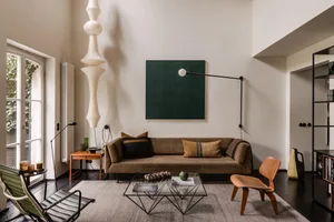 Modern living room with contemporary furniture, including a brown sofa, a glass coffee table, and minimalist décor.