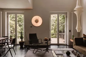 A modern living room featuring neutral-colored walls, furniture, and decor.