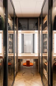 Modern minimalist wardrobe with glass panels and a wooden floor.
