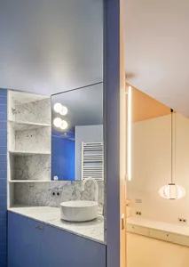 Modern minimalist bathroom with blue marble walls and white porcelain sink.