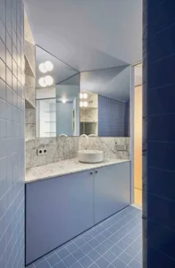 Modern minimalist bathroom with blue tiles and white marble accents