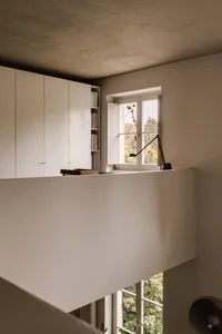 Interior view of a minimalist studio with concrete walls and open shelving.
