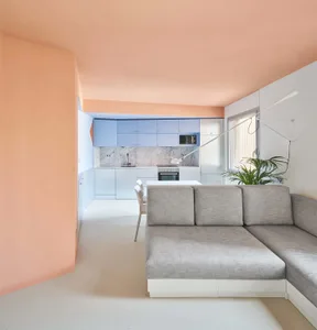 Modern apartment featuring a minimalist design with gray furniture and white walls and ceiling.
