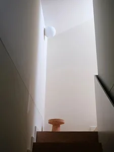 Minimalist interior design featuring a wooden staircase with modern lighting.