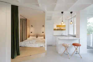 A minimalist studio apartment featuring white materials and a modern design.