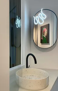 A modern bathroom design featuring a ceramic sink and minimalist decor.
