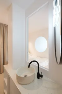 Modern bathroom with concrete sink and round window.