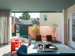 A contemporary living room featuring modern furniture, colorful walls, and a combination of materials.