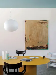 A modern workspace featuring a yellow steel table with books and a notepad.