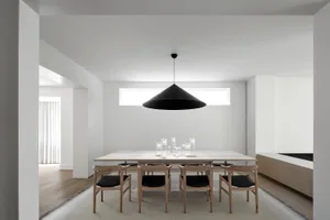 A modern minimalist dining room with a wooden dining table and chairs.