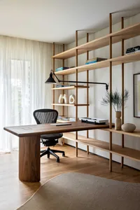A modern minimalistic home office featuring a wooden desk and bookshelf.