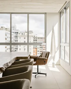 A modern minimalist living room with concrete furniture and white painted walls.