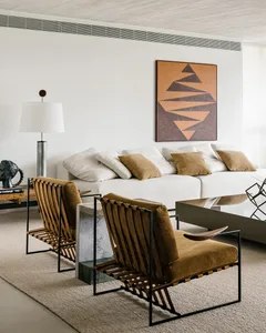 Modern minimalist living room featuring textured furniture and a geometric wall art.