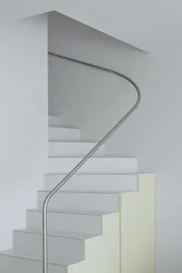 A modern white staircase with a steel handrail