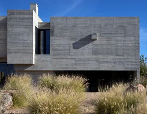 A minimalist building with a concrete exterior, featuring clean lines and a simple design.