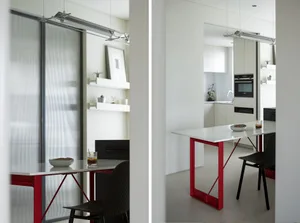 Minimalist kitchen with modern design, featuring red steel and glass elements.
