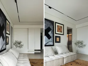 A modern living room with concrete flooring, minimalist decor, and abstract wall art.