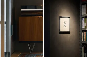 A wooden-framed artwork hanging on a wall, showcasing a minimalist design.