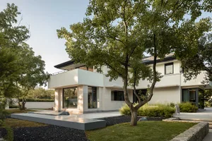 A modern residential exterior featuring concrete and glass materials.