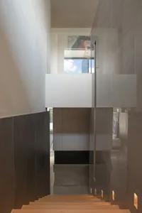 Modern staircase with wooden steps and glass railings.