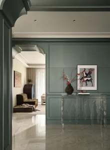 Glass console table with a vase containing red berries in a modern living room.