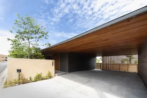 Concrete driveway with wooden carport and entranceway.