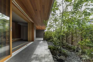 Modern entrance with wooden fence and greenery.