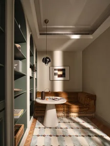 A modern living room featuring a brown sofa with a patterned carpet and a side table.