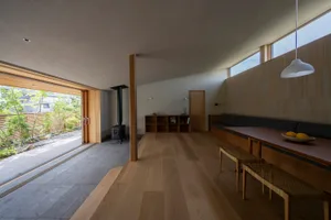 A modern living room with wooden flooring and a view of the garden.