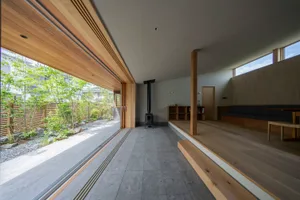 Modern minimalist living room with wooden flooring and furnishings.