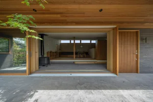 Modern minimalist residential interior with wood furnishings and concrete flooring.