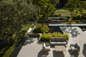 Modern outdoor living space featuring concrete patio, seating area, and landscaping.