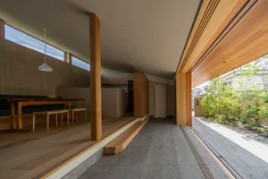 A modern residential interior featuring wooden flooring and natural light from large windows.