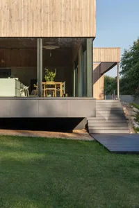 A modern residential building featuring a wooden exterior and glass windows.