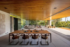 Modern living room with a wooden ceiling and large windows overlooking a garden