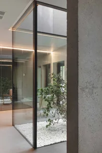 Minimalist office space featuring glass walls and concrete elements.