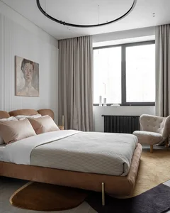 A minimalist bedroom featuring a brown velvet bed, beige curtains, and a concrete floor.