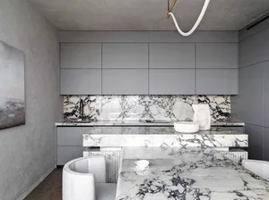 Modern minimalist kitchen with marble countertops and island.