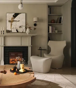 A cozy living room featuring neutral-toned fabric furniture and wooden accents, with a fireplace and bookshelf in the backgro