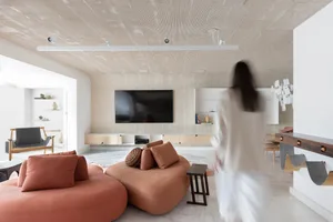 A modern living room featuring soft, comfortable furniture and a concrete ceiling and walls.