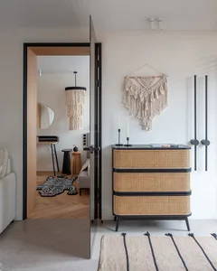 A minimalist bedroom featuring bohemian textiles and a woven chair.