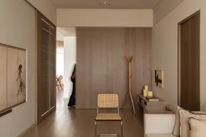 A minimalist living room featuring wooden furniture and textured fabric accents.