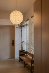 A minimalist living space featuring wooden furniture and a spherical light fixture.