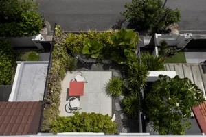 A modern design featuring concrete patio, rocks, and lush green plants on a rooftop or courtyard.
